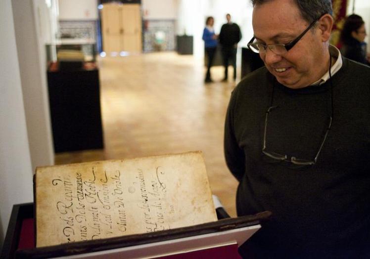 El exarqueólogo municipal, Emilio Diz, observa el original del 'Llibre dels Repartiments' durante su exposición en Orihuela.
