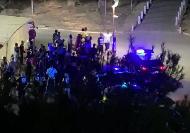 Inmigrantes en torno a un vehículo policial, en una imagen sacada de un vídeo.