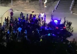 Inmigrantes en torno a un vehículo policial, en una imagen sacada de un vídeo.