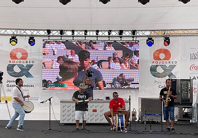 Actuación. El grupo de percusión colombiana actúa en el escenario, con el partido de Carlos Alcaraz de fondo en la pantalla.