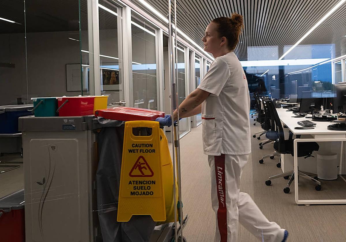 Una trabajadora de Limcamar empuja el carrito de limpieza.