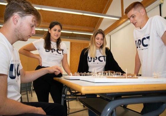 Estudiantes de Arquitectura de la UPCT junto a una maqueta.