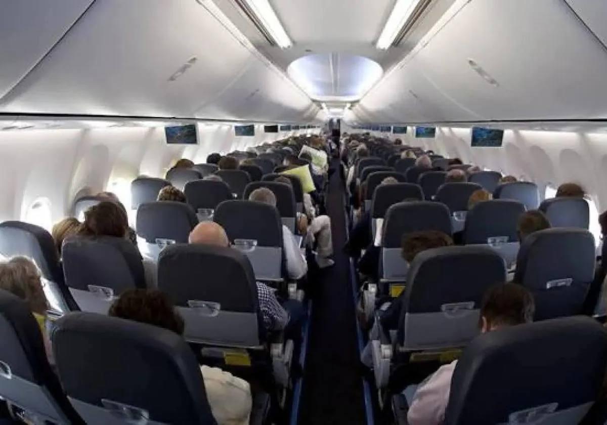 Vista interior de un avión con pasajeros.