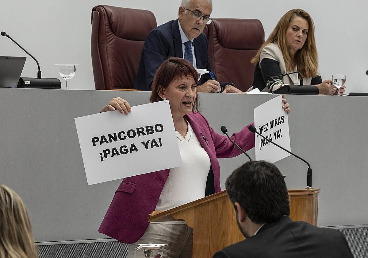 María Marín muesta un cartel donde se exige el pago de las ayudas del alquiler ya concedidas a los jóvenes de la Región.