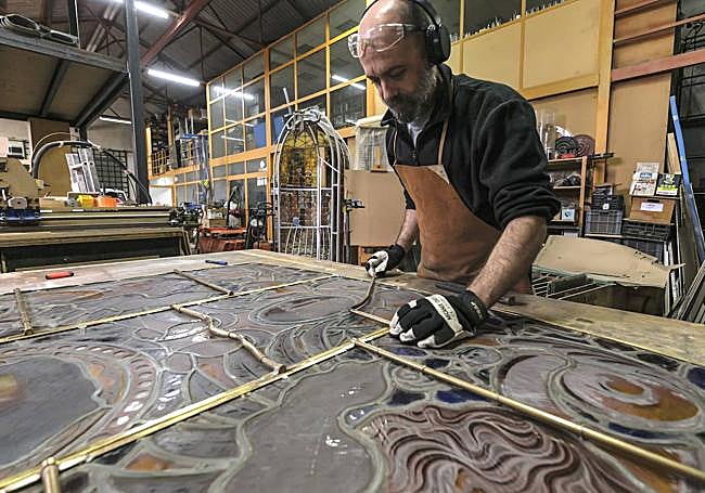 Rodrigo Muñoz en pleno trabajo de sustitución de los plomos dañados que unen los cristales que forman la vidriera.