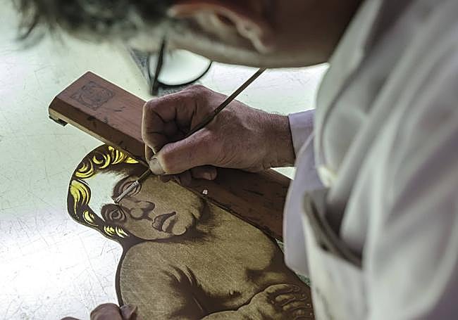 Retoques de pintura a uno de los querubines de la vidriera central.