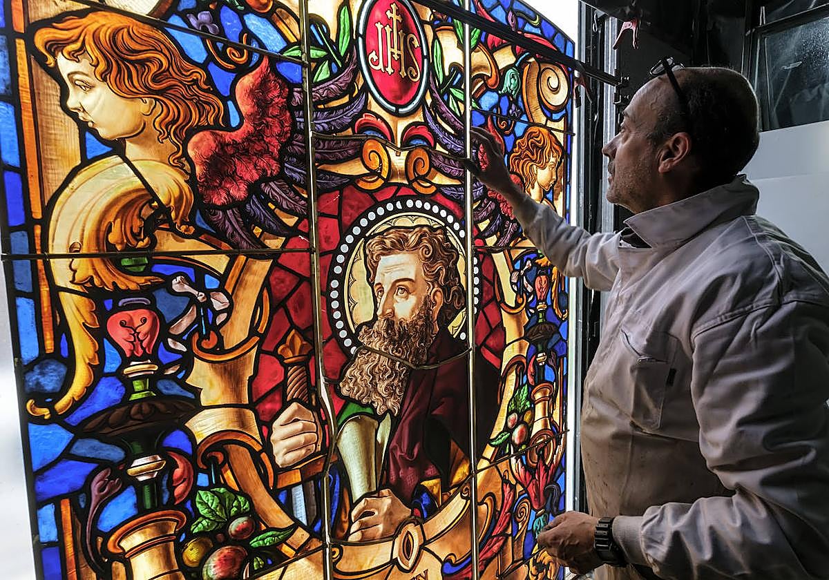 Pablo Muñoz revisa la vidriera dedicada a San Pablo para comprobar los detalles.