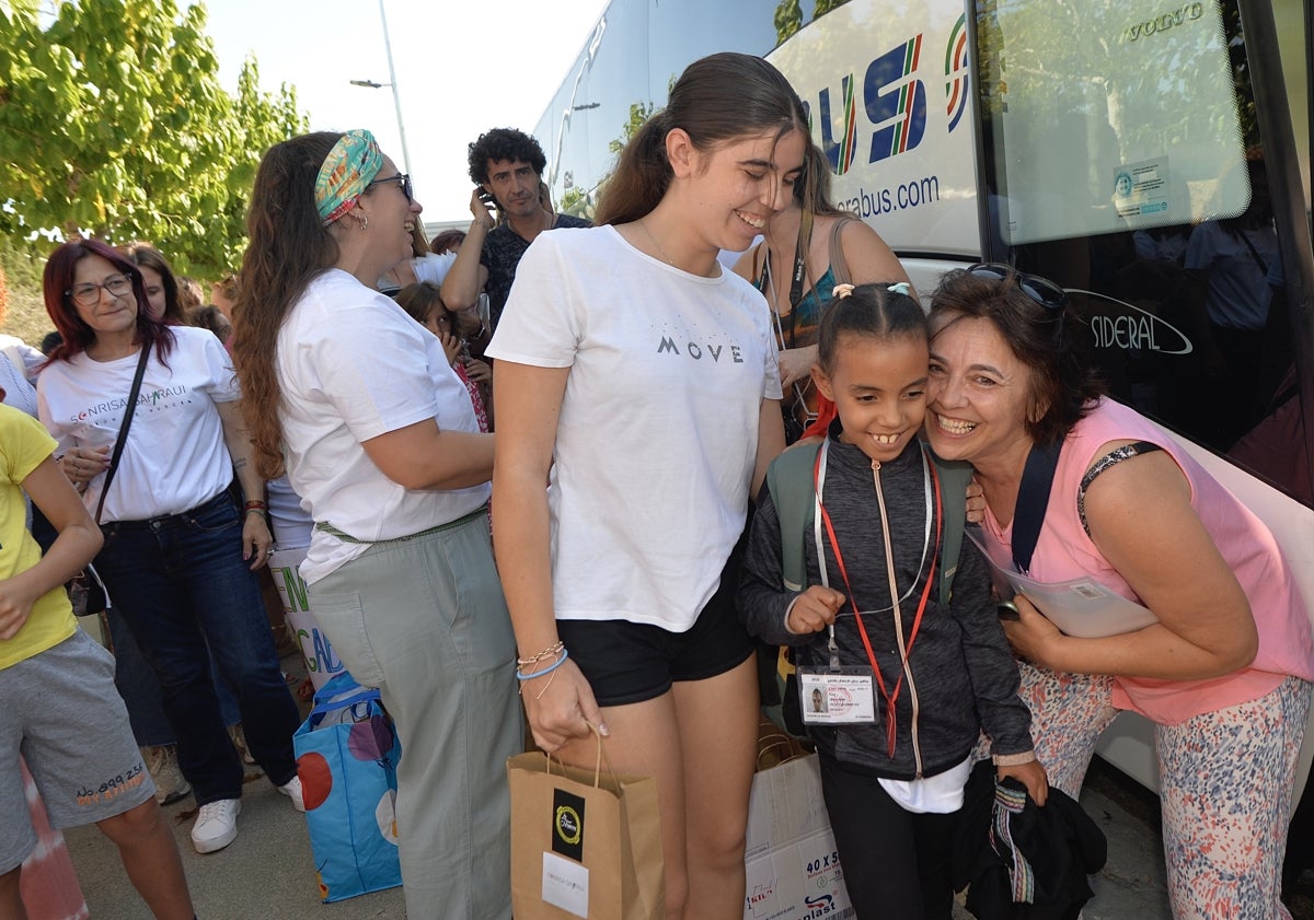 Imagen principal - Arriba, María Luisa con Gali; abajo a la izquierda, Úrsula y Andrés reciben a Wafaa; abajo a la derecha, recibimiento de otro de los menores. 