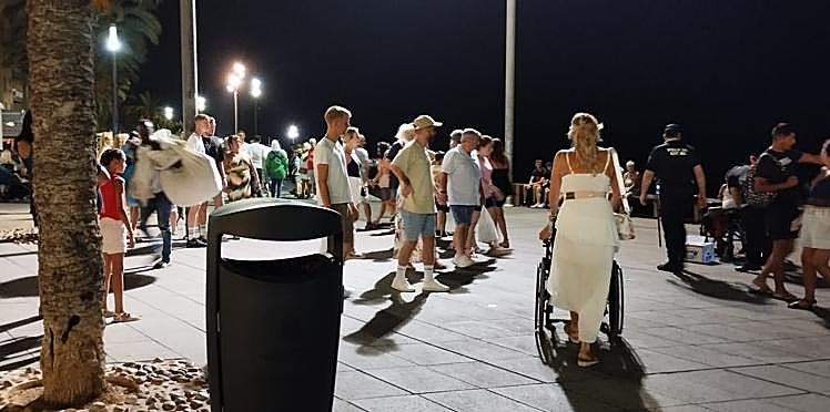 A la izquierda, un mantero abandona andando el paseo Juan Aparicio a escasos metros de un agente de la Policía Local (a la derecha), cerca del monumento al Hombre del Mar.