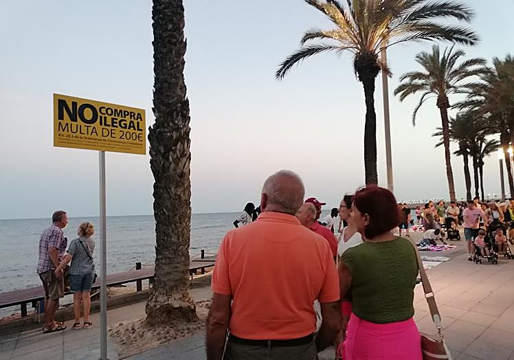 Dos parejas se detienen curiosas a leer el contenido del nuevo cartel.