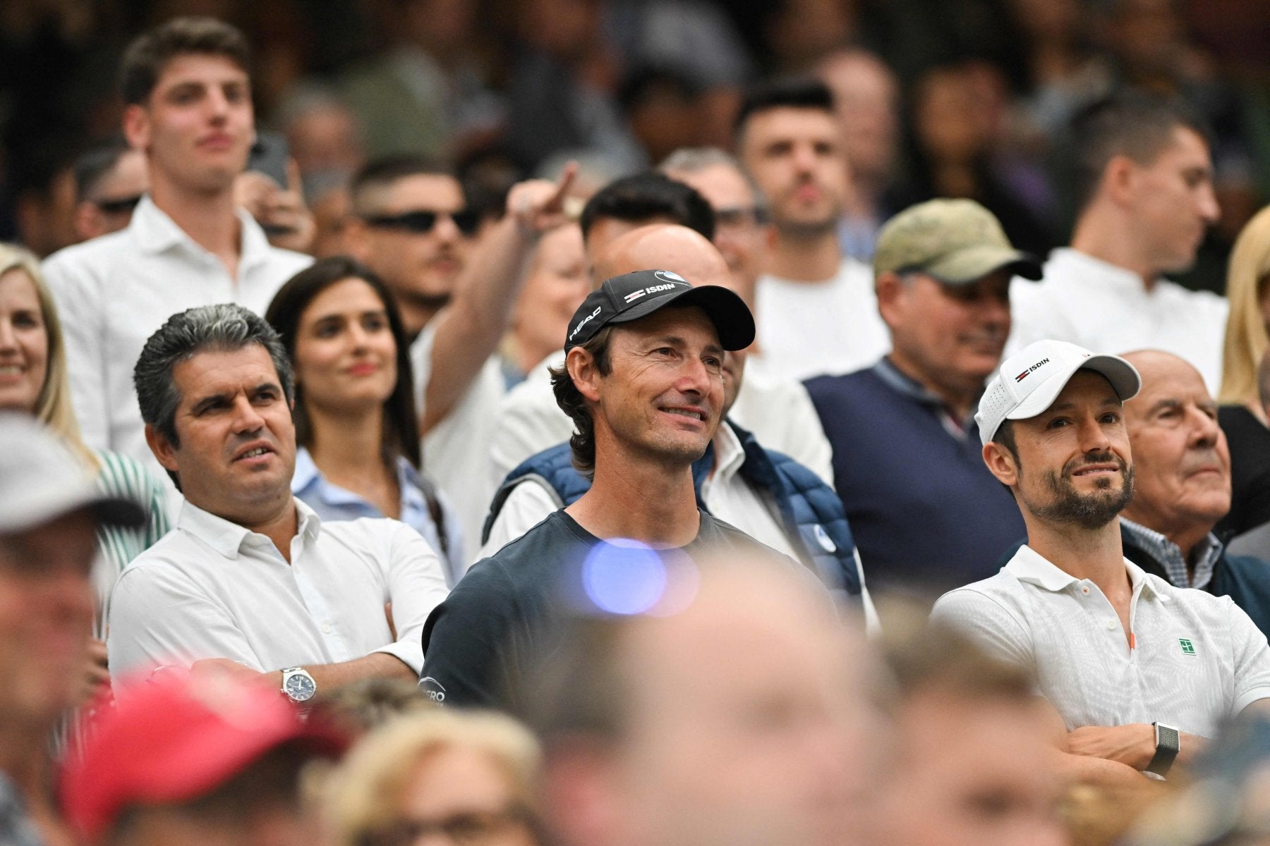 Juan Carlos Ferrero, entre Carlos Alcaraz González y Juanjo Moreno, escuchando a Carlos Alcaraz tras imponerse en tercera ronda de Wimbledon a Frances Tiafoe.