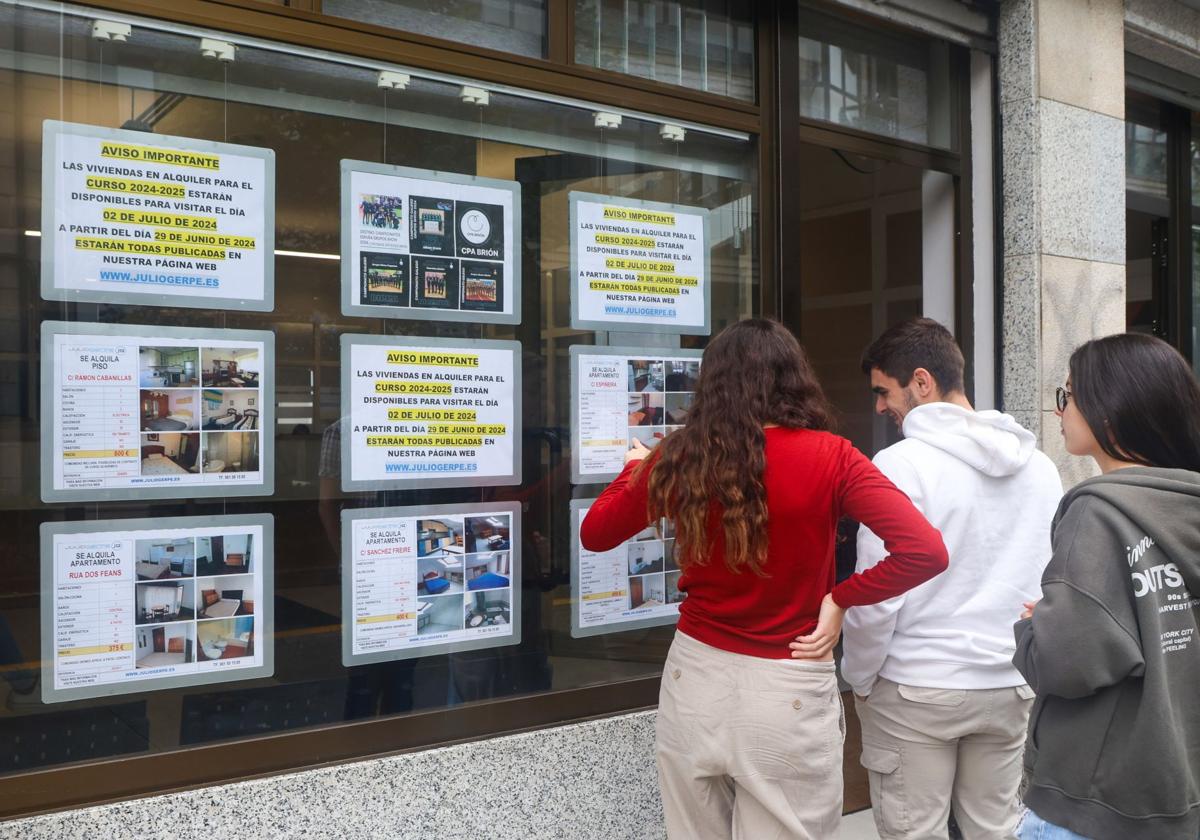 Un grupo de estudiantes consulta los pisos en alquiler de una inmobiliaria.