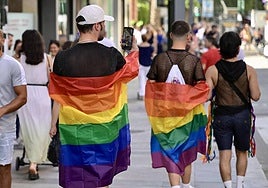 Dos jóvenes portan la bandera del colectivo LGTBI.