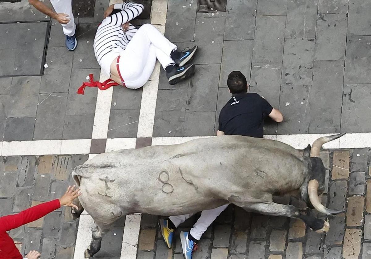 Dos corredores caídos, este sábado, durante el encierro de San Fermín.