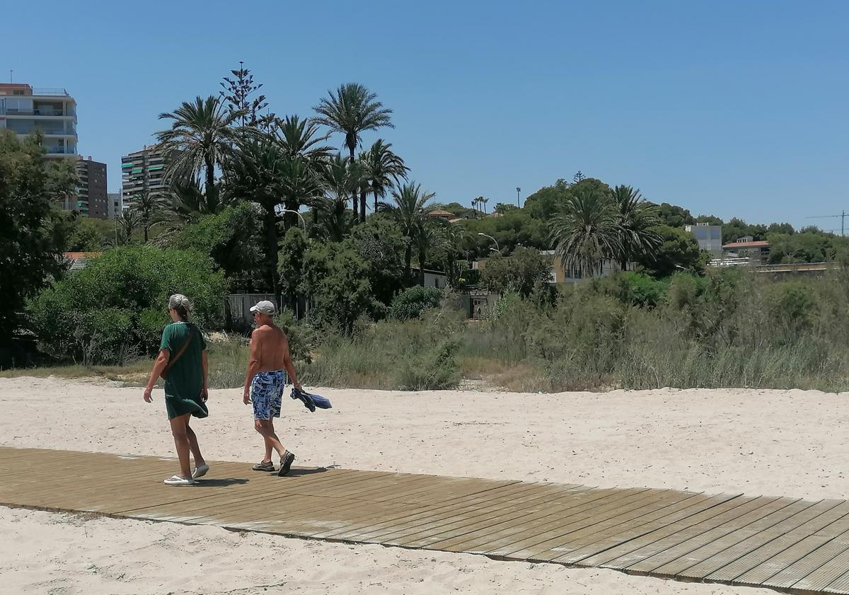 Imagen principal - La pasarela está hecha a base de listones de madera anclados a la base de la antigua carretera sobre la desembocadura del río Nacimiento.