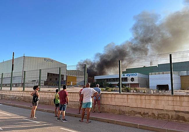 Curiosos se acercan a observar el avance del incendio.