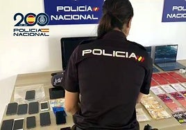 Una agente de la Policía Nacional con los efectos incautados.