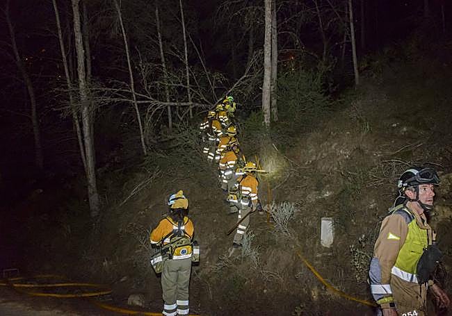 Una brigada de bomberos hace frente a las llamas.