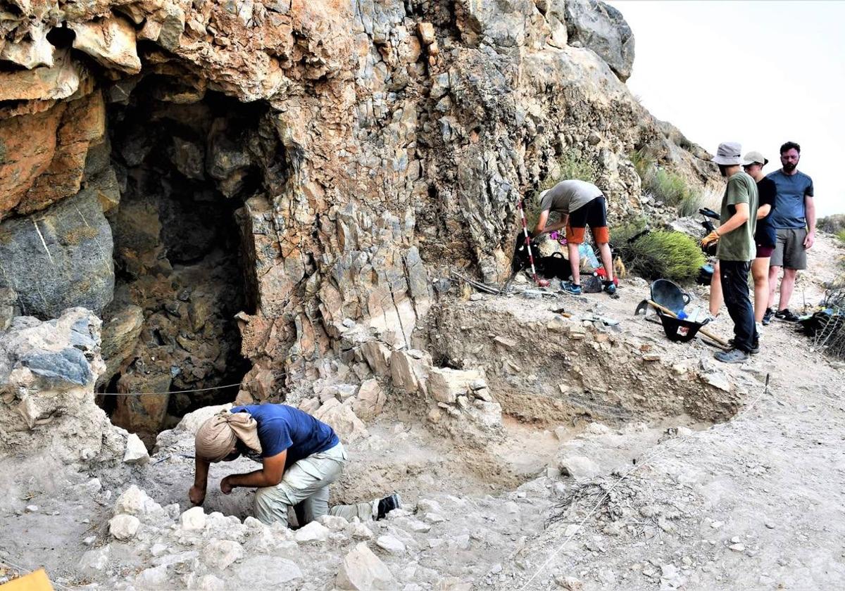 Voluntarios y estudiantes trabajando en la cueva del yacimiento íbero de la Balumba en una imagen de archivo.