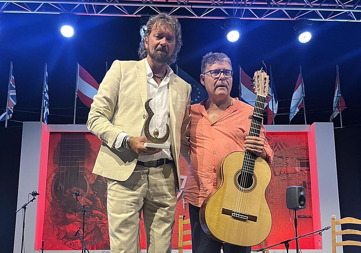 Jesús Castilla Rey sostiene su galardón junto a su guitarrista de acompañamiento.