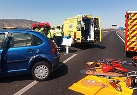 Sanitarios y bomberos atienden a una de las víctimas de los accidentes registrados este sábado en la autovía A-7.