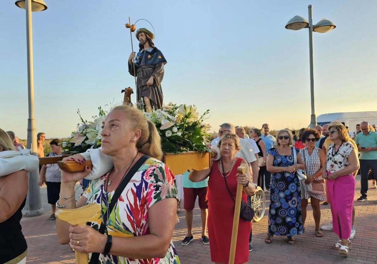 Un grupo de mujeres portan la imagen de San Roque, en la procesión celebrada en El Mojón.