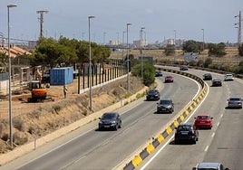 Una máquina prepara el terreno para poner los paneles, junto a la vía rápida de La Manga.