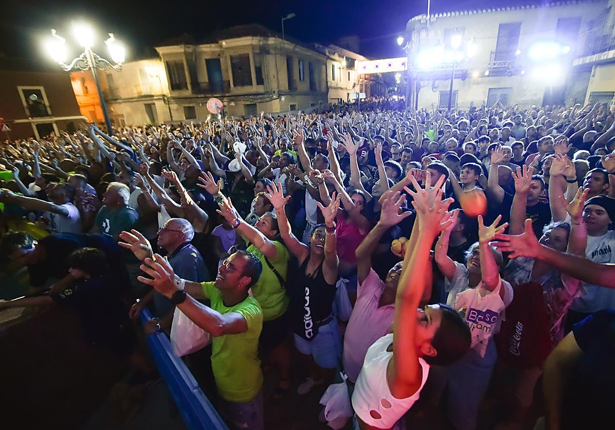 Los vecinos levantan los brazos para recoger las pitanzas.