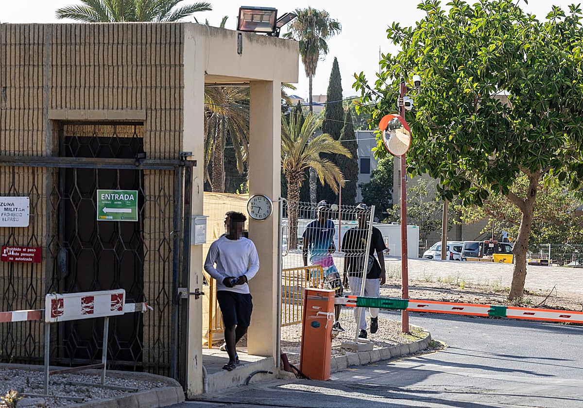 Varios inmigrantes salen del campamento instalado en el antiguo hospital Naval de Cartagena.