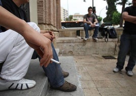 Jóvenes fumando en una plaza de Murcia.