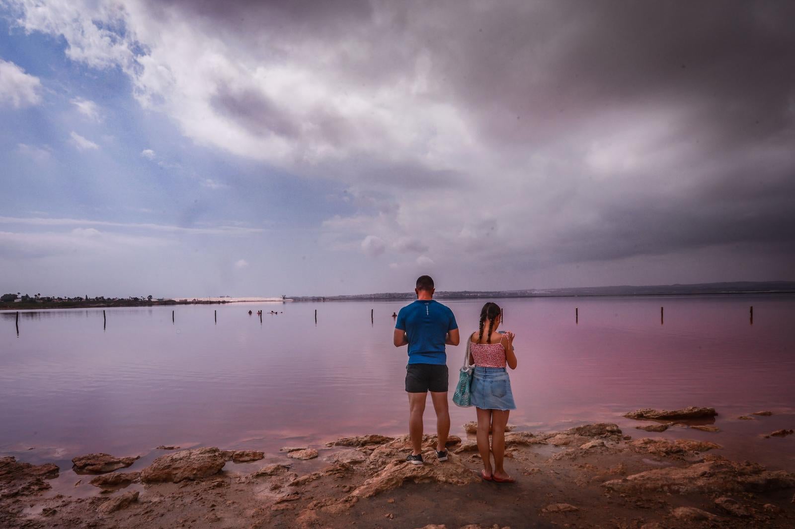 Los turistas toman las orillas de la Laguna Rosa de Torrevieja pese a la prohibición al baño