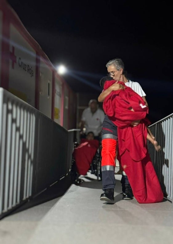 Una voluntaria atiende a uno de los menores que han desembarcado de la patera.