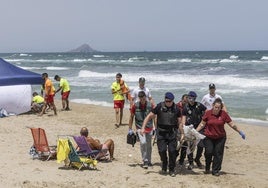 Policías y socorristas trasladan el cuerpo de un joven ahogado en julio en La Manga.