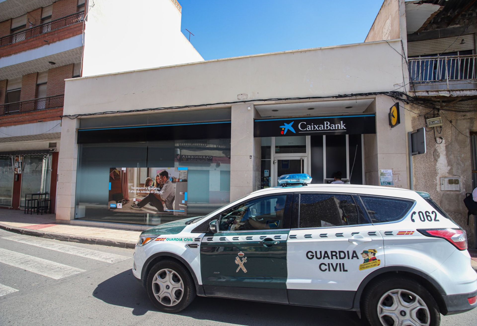 Un coche de la Guardia Civil frente al banco del atraco.