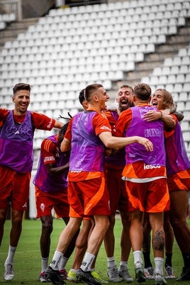 Los jugadores del Real Murcia se abrazan celebrando un gol durante un entrenamiento previo al partido ante la AD Mérida en el estadio Enrique Roca.