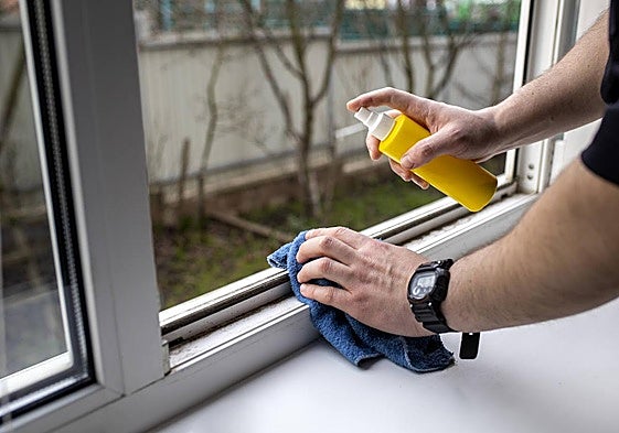 Una persona limpiando la ventana.