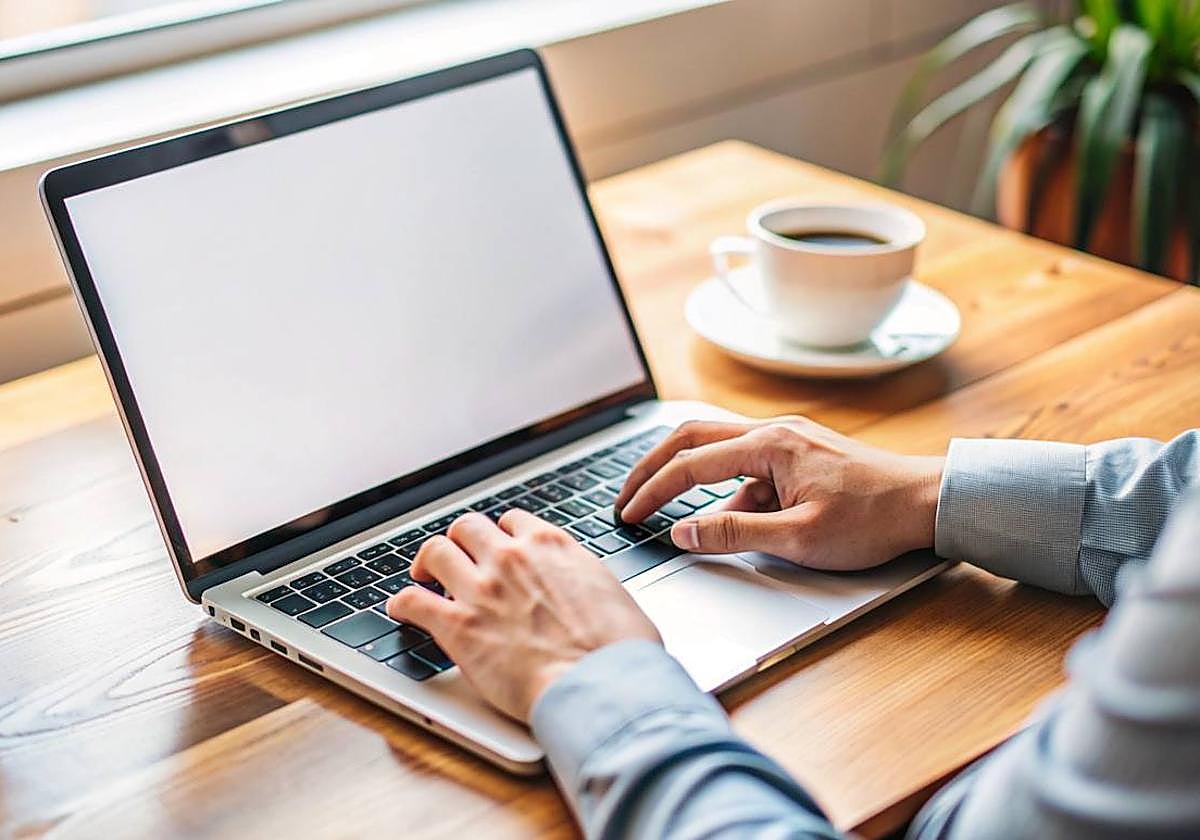 Un hombre tecleando en su ordenador.