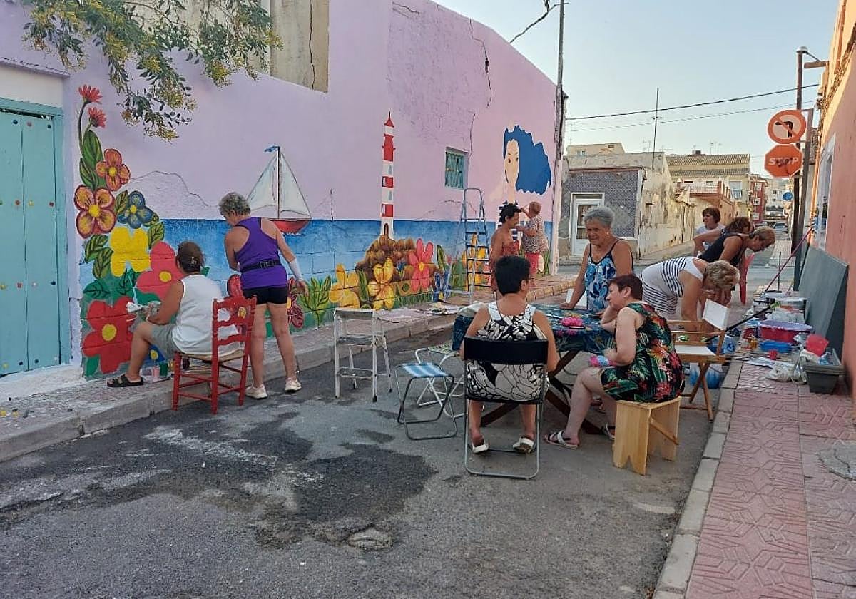 Vecinas colaboran en la decoración de la calle Hortaleza, en el barrio de la Ermita.
