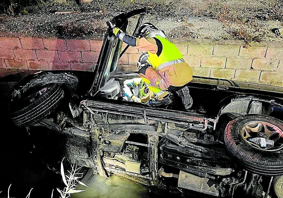 Un bombero rescata a un conductor ebrio, que cayó a una acequia de Murcia, el año pasado.