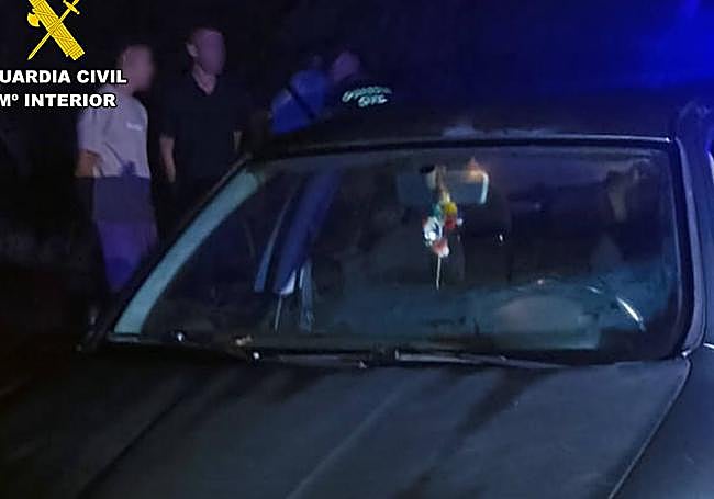 Los detenidos tras ser sorprendidos, junto a su vehículo.