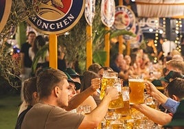 Asistentes brindan con jarras de cerveza durante una pasada edición del evento.