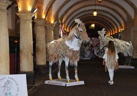 Una mujer contempla la exposición de los Caballos del Vino en la cuadra principal de las Caballerizas Reales de Córdoba.