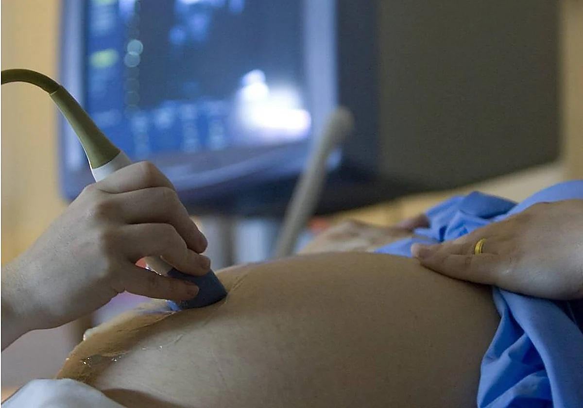 Un sanitario realiza una ecografía a una mujer embarazada.