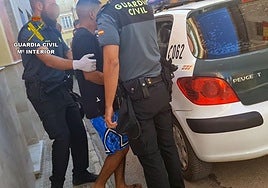 Los agentes metiendo en un vehículo al arrestado.