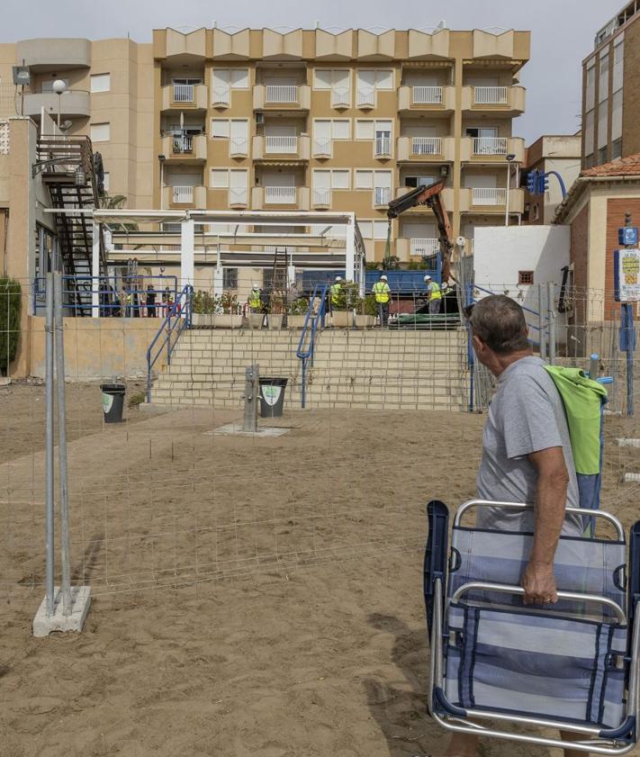 Imagen secundaria 2 - Trabajos de desmontaje del restaurante Miramar de Mazarrón, este lunes. | Un vecino observa a los operarios trabajando en el local, que será derribado los próximos días.