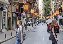 Banderas españolas se suceden en la calle Puerta Nueva, zona del centro de la ciudad de Murcia.