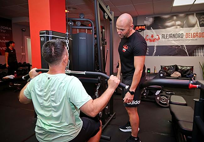 El preparador físico Alejandro Delgado guía el entrenamiento de un cliente.