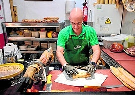 Un trabajador del establecimiento Parlamento Andaluz, en la plaza del Romea de Murcia, prepara para llevar las sobras de una comida.