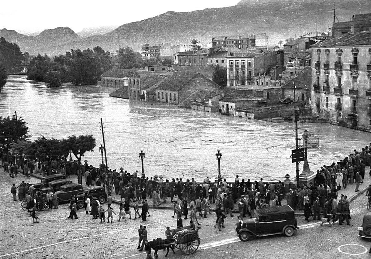Muchos curiosos. El río Segura a su paso por el Puente Viejo, en la espeluznante crecida que retrató el gran fotógrafo Juan López en el año 1944 y que se conserva en el Archivo Almudí.