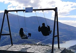 Un hombre y una joven se balancean en un columpio, en una foto de archivo.